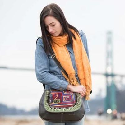 Woman with a fan-covered leather bag with mola design